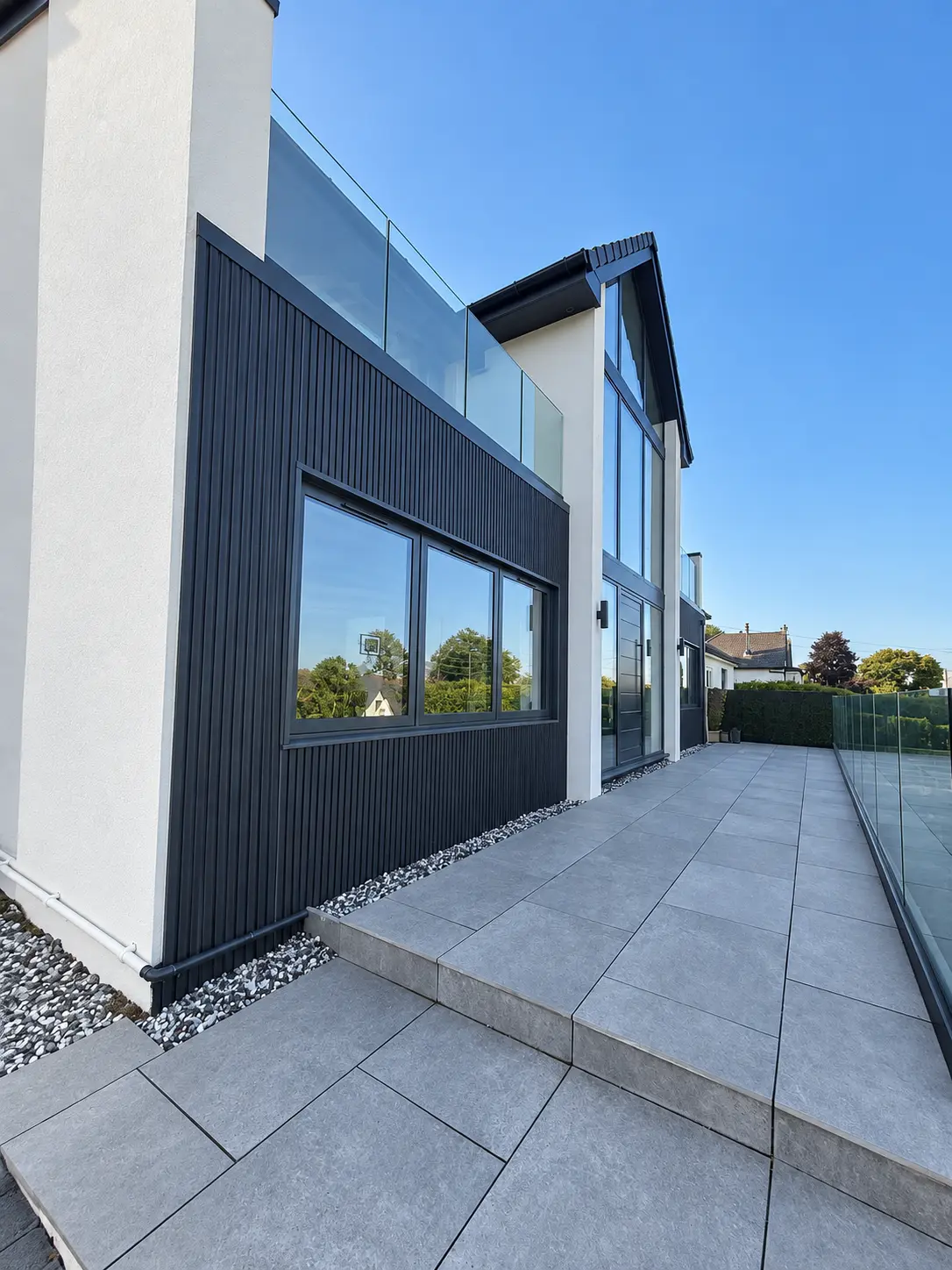 Dark aluminium glazing following the pitched gable end of a modern home