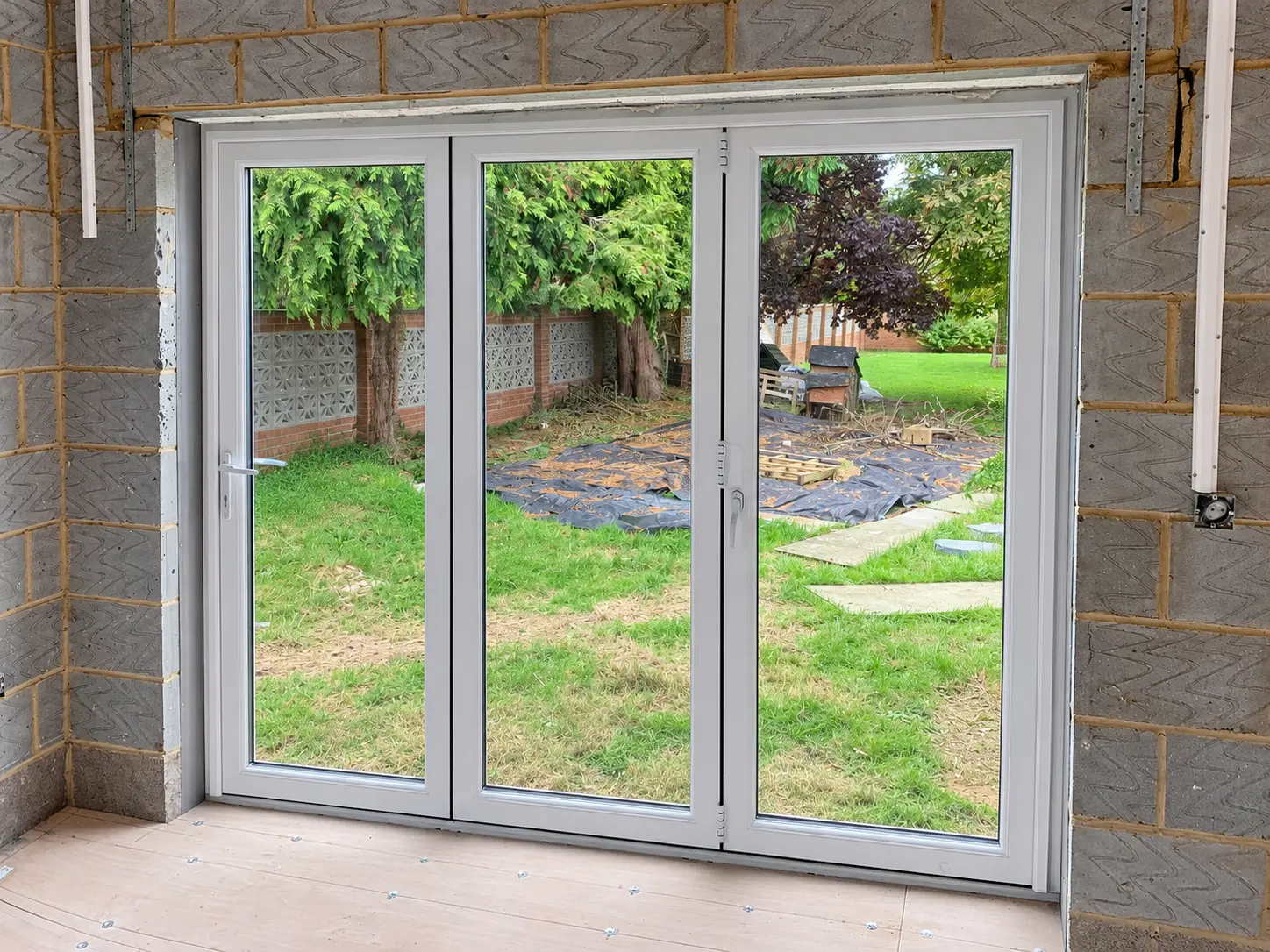 Interior installation view of white three-panel bifold doors
